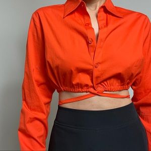 Cropped button-down/up with straps around the waist.